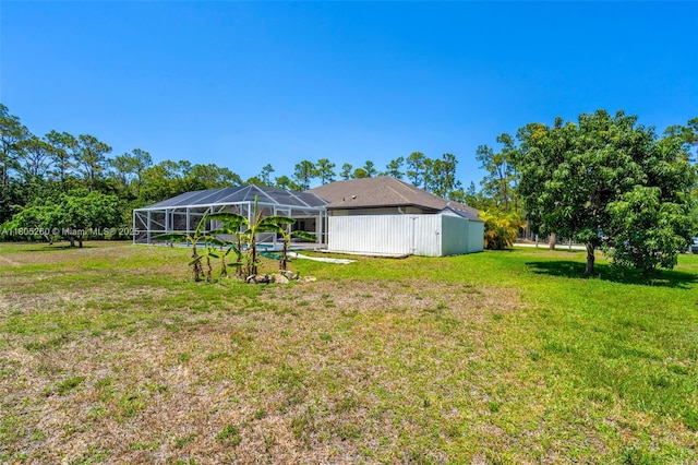 view of grassy yard with a lanai
