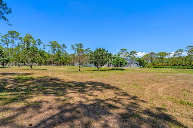 view of green lawn featuring a lanai
