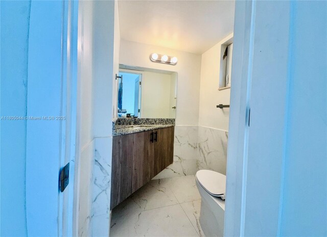 1701 NE 191st St Unit A108, Miami, FL 33179 - bathroom featuring marble look tile flooring, vanity, and wainscoting