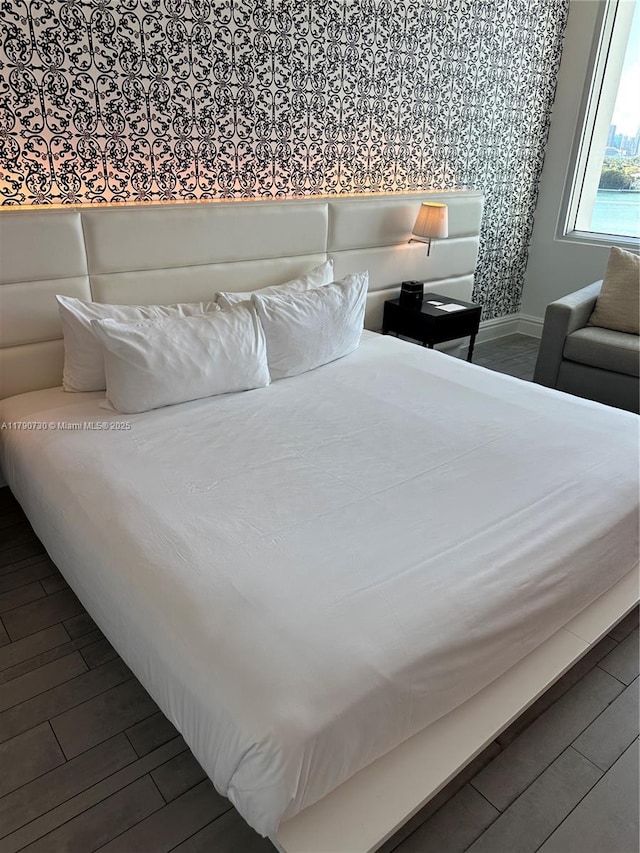 1100 W Ave Unit 1206, Miami Beach, FL 33139 - bedroom with dark wood-style floors, baseboards, and wallpapered walls