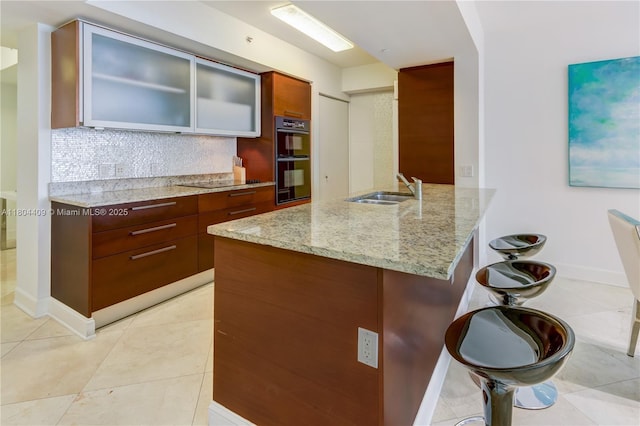 1830 S Ocean Dr Unit 3804, Hallandale Beach, FL 33009 - kitchen with a sink, backsplash, light stone counters, a peninsula, and a kitchen bar