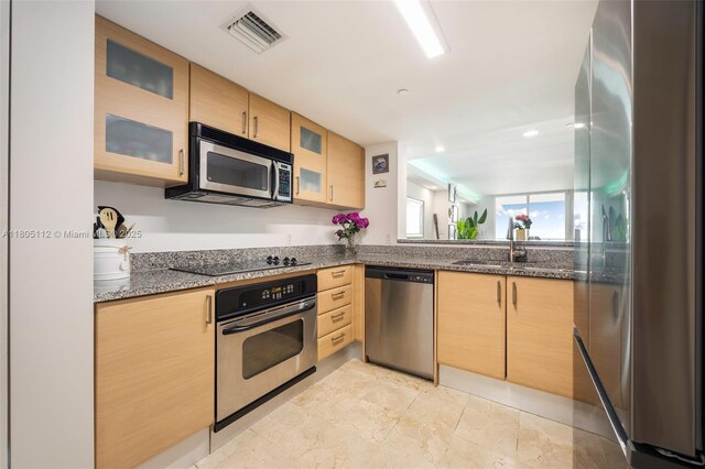 2101 Brickell Ave Unit 807, Miami, FL 33129 - kitchen with stainless steel appliances, light brown cabinets, a sink, and glass insert cabinets