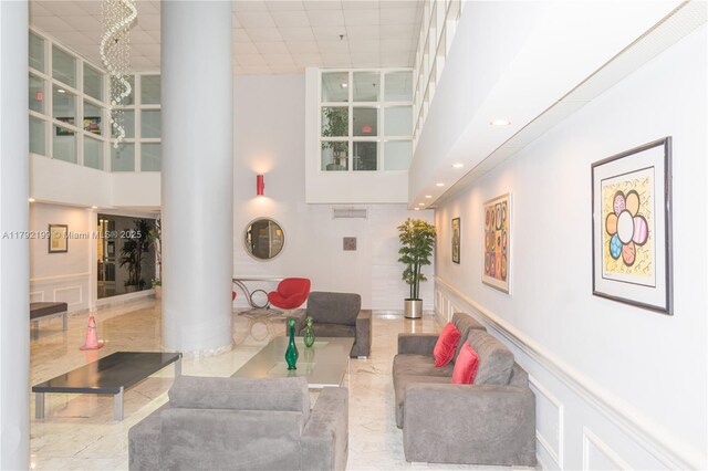 9341 Collins Ave Unit 1204, Surfside, FL 33154 - living room with decorative columns, a towering ceiling, a wainscoted wall, and recessed lighting