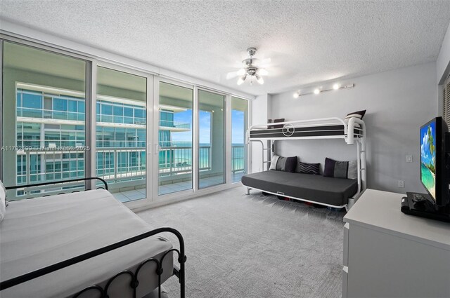 9341 Collins Ave Unit 1204, Surfside, FL 33154 - bedroom featuring access to exterior, carpet flooring, a textured ceiling, and expansive windows