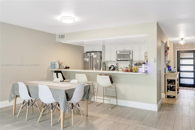1033 NW 124th Ave, Pembroke Pines, FL 33026 - dining space featuring baseboards and light wood-type flooring