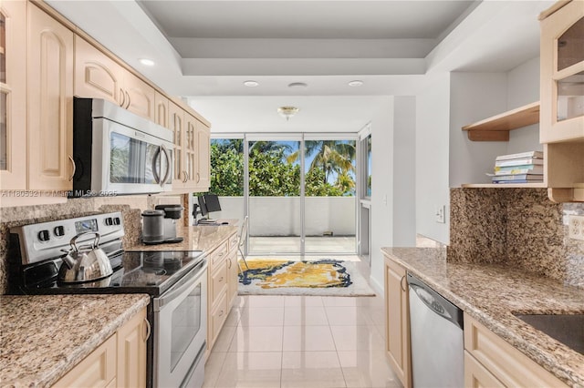 2655 Collins Ave Unit 411, Miami Beach, FL 33140 - kitchen with stainless steel appliances, decorative backsplash, glass insert cabinets, light brown cabinets, and recessed lighting
