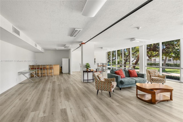 2655 Collins Ave Unit 411, Miami Beach, FL 33140 - living area with a textured ceiling, wood finished floors, floor to ceiling windows, and baseboards