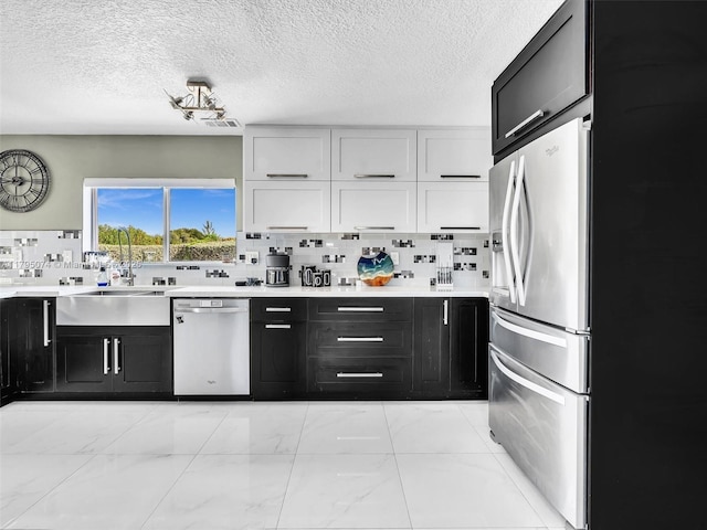 15066 SW 38th Ter, Miami, FL 33185 - kitchen featuring appliances with stainless steel finishes, dark cabinetry, light marble finish floors, white cabinets, and light countertops