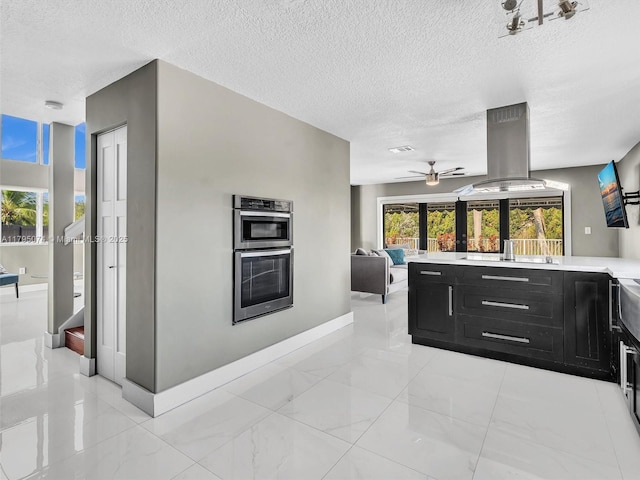 15066 SW 38th Ter, Miami, FL 33185 - kitchen with dark cabinets, light countertops, island range hood, a textured ceiling, and ceiling fan