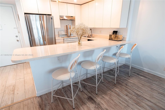 1817 S Ocean Dr Unit 0918, Hallandale Beach, FL 33009 - kitchen with white electric range, freestanding refrigerator, a sink, under cabinet range hood, and wood finished floors