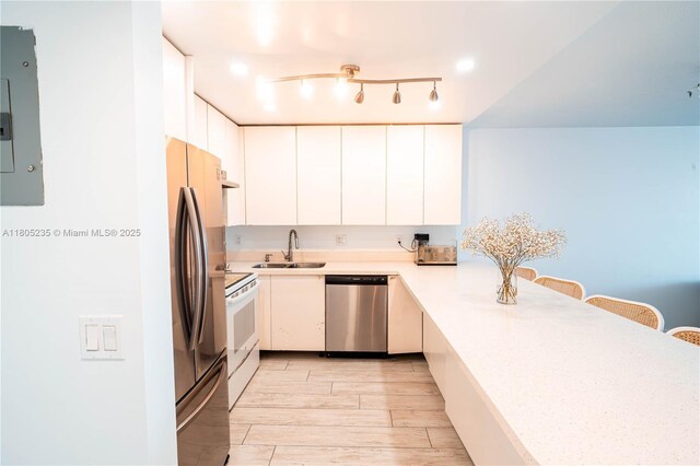 1817 S Ocean Dr Unit 0918, Hallandale Beach, FL 33009 - kitchen featuring stainless steel appliances, a sink, light countertops, a kitchen bar, and white cabinetry