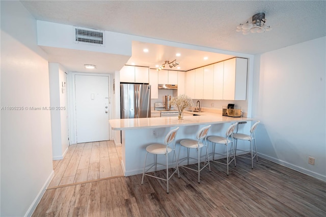 1817 S Ocean Dr Unit 0918, Hallandale Beach, FL 33009 - kitchen featuring freestanding refrigerator, light wood-style floors, a peninsula, a kitchen bar, and a sink