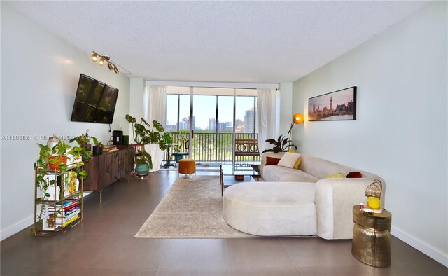 20379 W Country Club Dr Unit 836, Aventura, FL 33180 - living room featuring floor to ceiling windows, a textured ceiling, and baseboards