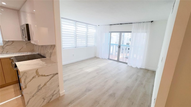 701 Collins Ave Unit 1F, Miami Beach, FL 33139 - unfurnished dining area featuring light wood-type flooring and recessed lighting