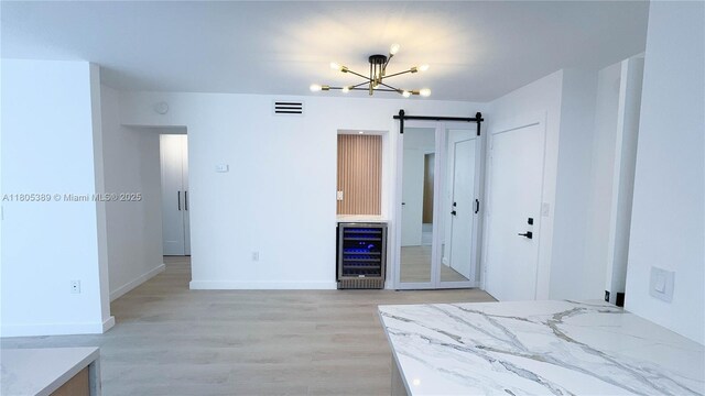701 Collins Ave Unit 1F, Miami Beach, FL 33139 - bedroom with beverage cooler, a chandelier, light wood-style floors, and a barn door