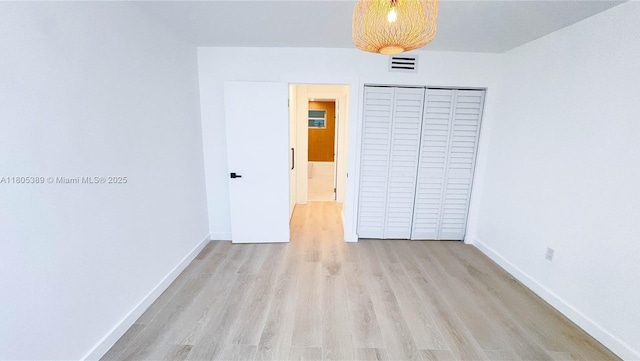 701 Collins Ave Unit 1F, Miami Beach, FL 33139 - unfurnished bedroom with light wood-style floors and a closet
