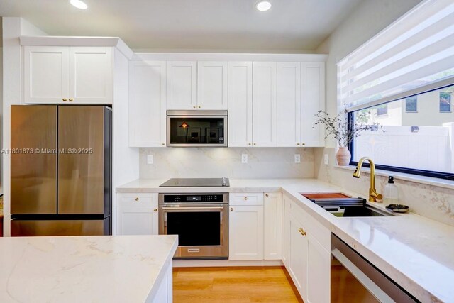 10602 W 33rd Way, Hialeah, FL 33018 - kitchen featuring stainless steel appliances, a sink, white cabinets, recessed lighting, and light stone counters