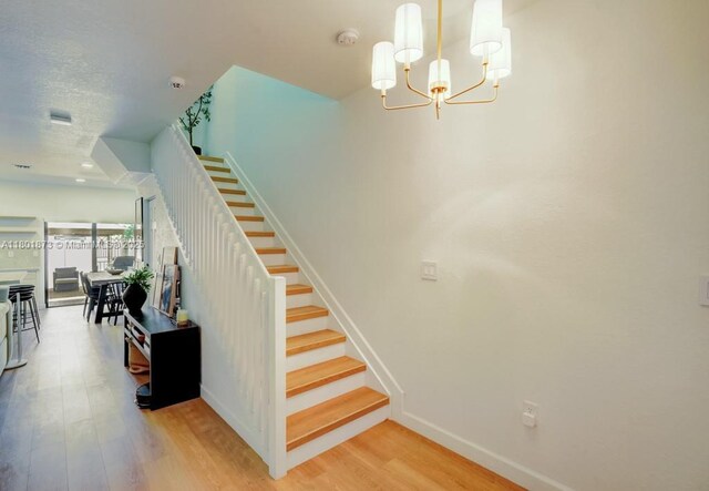 10602 W 33rd Way, Hialeah, FL 33018 - stairs with wood finished floors, baseboards, and a chandelier