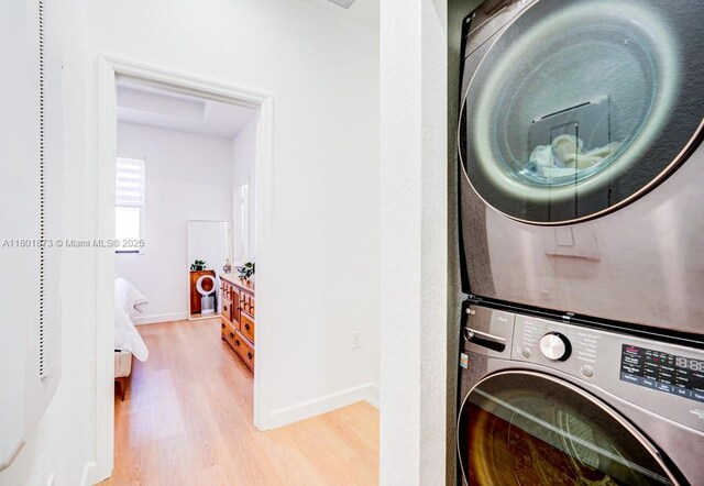10602 W 33rd Way, Hialeah, FL 33018 - laundry room with stacked washing machine and dryer, wood finished floors, and baseboards