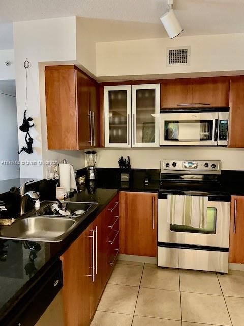 3232 SW 22nd Ter Unit 1303, Miami, FL 33145 - kitchen featuring appliances with stainless steel finishes, a sink, dark countertops, and light tile patterned floors