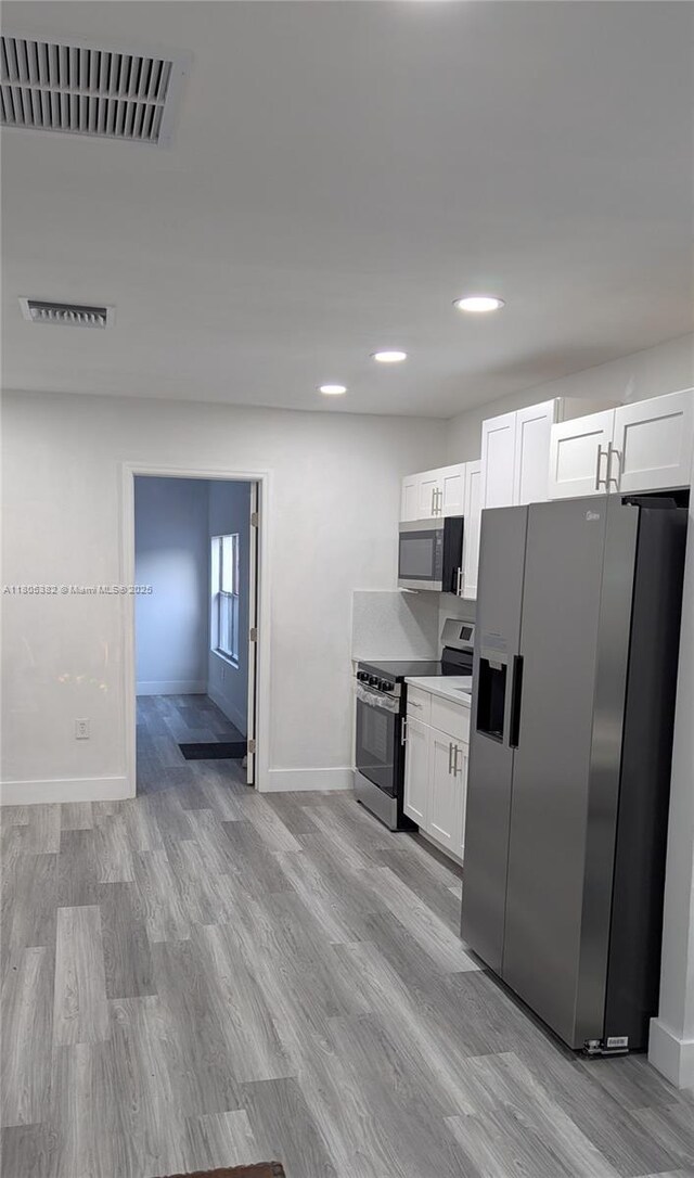 3601 N 72nd Ave, Hollywood, FL 33024 - kitchen featuring stainless steel appliances, baseboards, light wood-style flooring, white cabinets, and recessed lighting