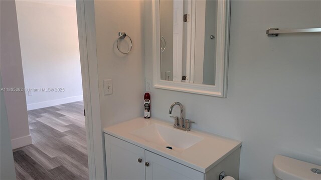 3601 N 72nd Ave, Hollywood, FL 33024 - half bathroom featuring vanity, toilet, and wood finished floors