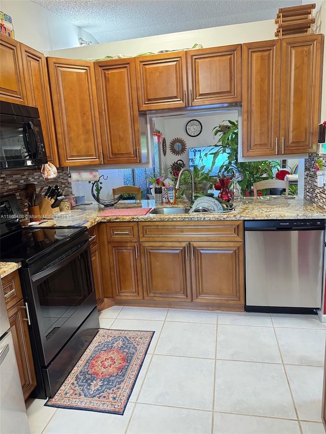 9481 W Elm Ln, Miramar, FL 33025 - kitchen with black appliances, brown cabinetry, backsplash, light stone countertops, and a textured ceiling