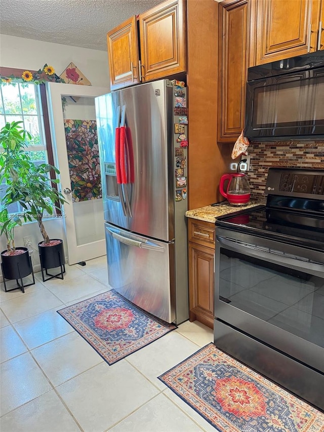 9481 W Elm Ln, Miramar, FL 33025 - kitchen featuring electric stove, stainless steel fridge, black microwave, brown cabinetry, and backsplash