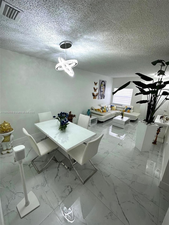 2207 SE 23rd Ave Unit 2207, Homestead, FL 33035 - dining room featuring a chandelier, a textured ceiling, and marble look tiles