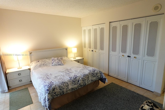17011 N Bay Rd Unit 408, Sunny Isles Beach, FL 33160 - bedroom with multiple closets, light tile patterned floors, and a textured ceiling
