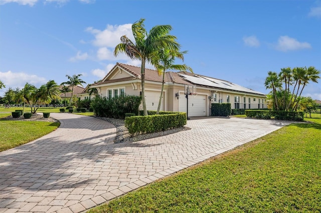 5630 N Sterling Ranch Dr, Davie, FL 33314 - ranch-style home featuring decorative driveway, a garage, solar panels, stucco siding, and a tile roof
