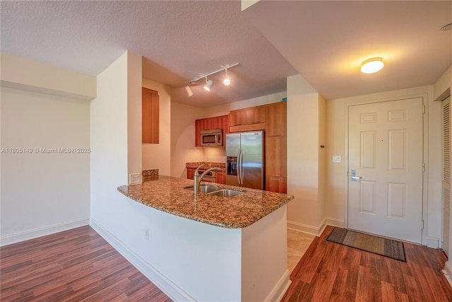 510 NW 84th Ave Unit 303, Plantation, FL 33324 - kitchen featuring stainless steel appliances, brown cabinetry, a sink, wood finished floors, and a peninsula