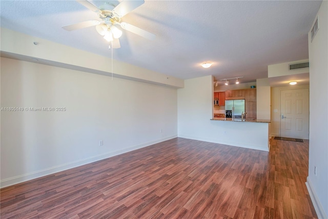 510 NW 84th Ave Unit 303, Plantation, FL 33324 - unfurnished living room with dark wood-style flooring, a ceiling fan, track lighting, baseboards, and a textured ceiling