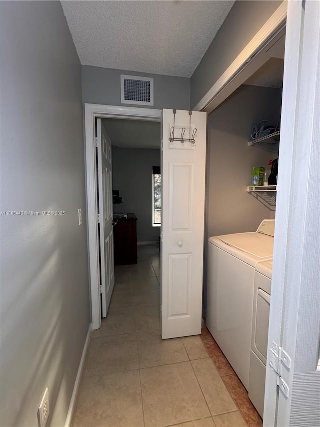 475 SE 20th Ln, Homestead, FL 33033 - laundry room with washer and dryer, light tile patterned floors, a textured ceiling, and baseboards