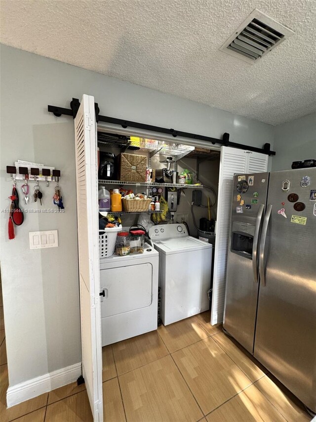 7005 NW 173rd Dr Unit 1702, Hialeah, FL 33015 - washroom featuring a barn door, independent washer and dryer, a textured ceiling, and wood finished floors