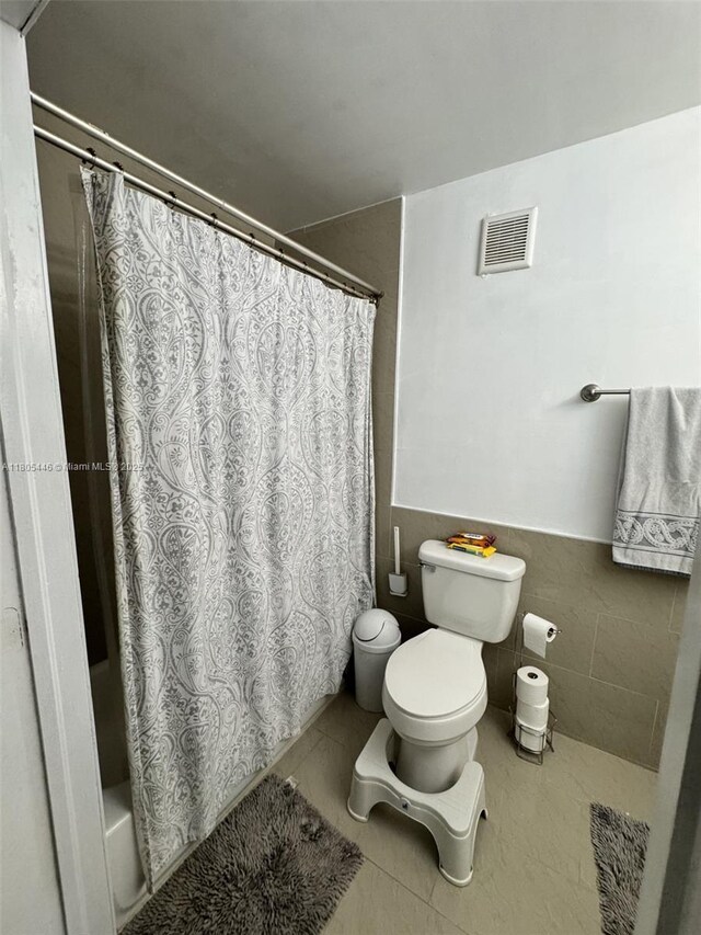 7005 NW 173rd Dr Unit 1702, Hialeah, FL 33015 - full bath featuring toilet, tile patterned flooring, and a wainscoted wall