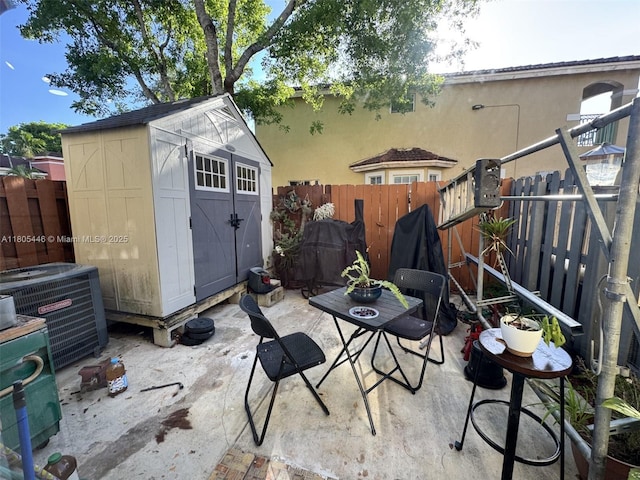 7005 NW 173rd Dr Unit 1702, Hialeah, FL 33015 - view of patio featuring central AC unit, a storage shed, a fenced backyard, and an outdoor structure