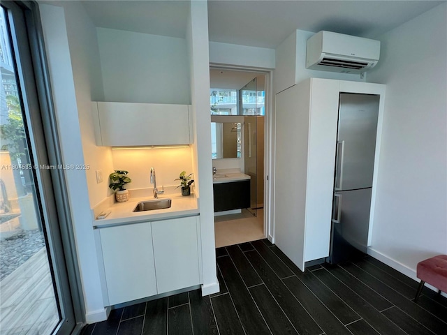 851 NE 1st Ave Unit Caba Pb23, Miami, FL 33132 - kitchen with a sink, a wall unit AC, dark wood finished floors, white cabinetry, and light countertops