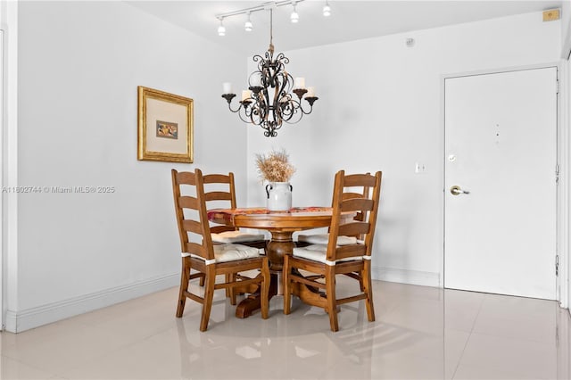 5700 Collins Ave Unit 7G, Miami Beach, FL 33140 - dining space with a chandelier, baseboards, rail lighting, and light tile patterned floors