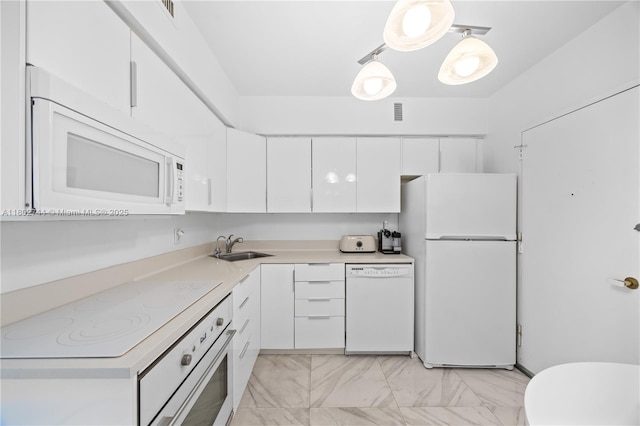 5700 Collins Ave Unit 7G, Miami Beach, FL 33140 - kitchen with white appliances, white cabinets, light countertops, a sink, and light marble finish flooring