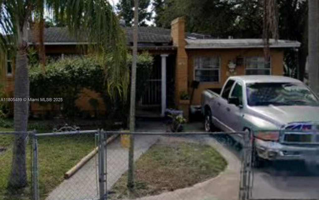 1076 NW 77th St, Miami, FL 33150 - view of front of house with a fenced front yard and a chimney