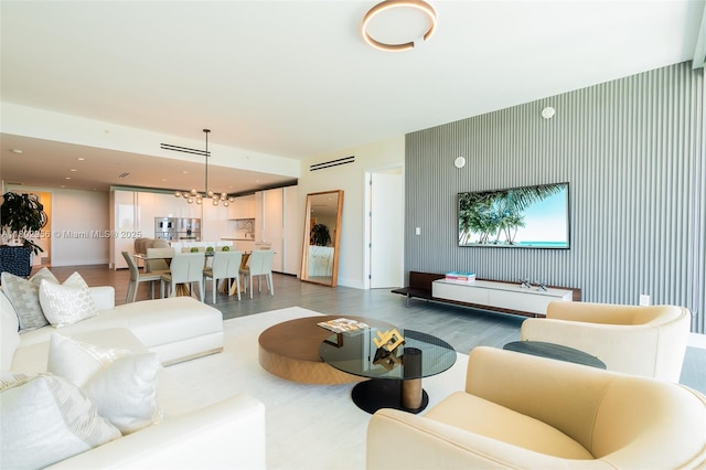 10203 Collins Ave Unit 302, Bal Harbour, FL 33154 - living room featuring an accent wall, wood finished floors, recessed lighting, baseboards, and a chandelier