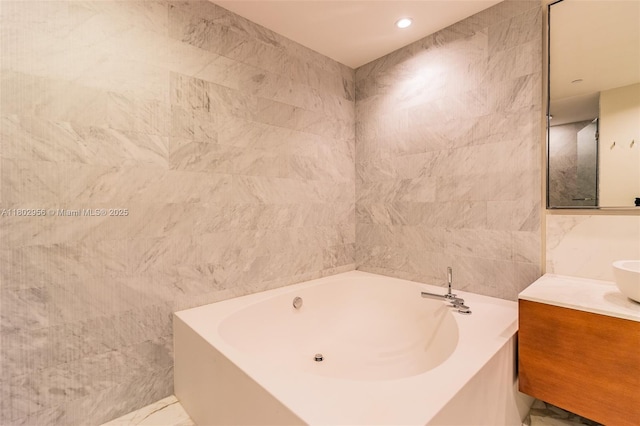 10203 Collins Ave Unit 302, Bal Harbour, FL 33154 - bathroom with a garden tub, vanity, and tile walls