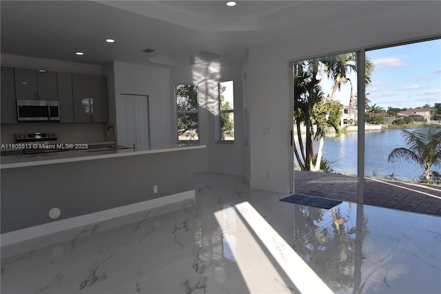 2925 SW 133rd Ave, Miramar, FL 33027 - interior space with recessed lighting, a water view, baseboards, a sink, and light marble finish flooring