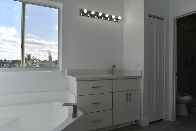 2925 SW 133rd Ave, Miramar, FL 33027 - bathroom with toilet, a closet, vanity, a bath, and wood finished floors