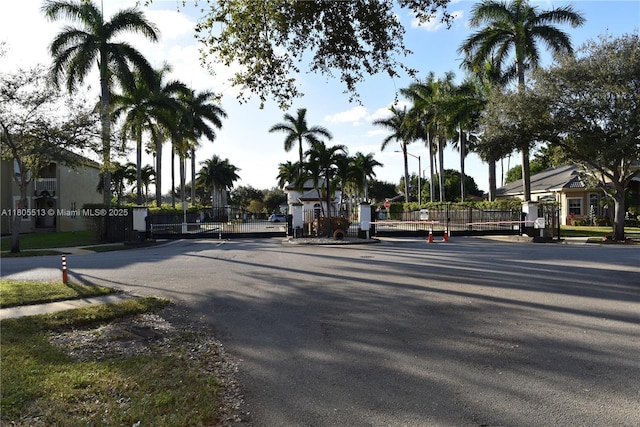 2925 SW 133rd Ave, Miramar, FL 33027 - view of asphalt road with a gated entry, a gate, sidewalks, and curbs