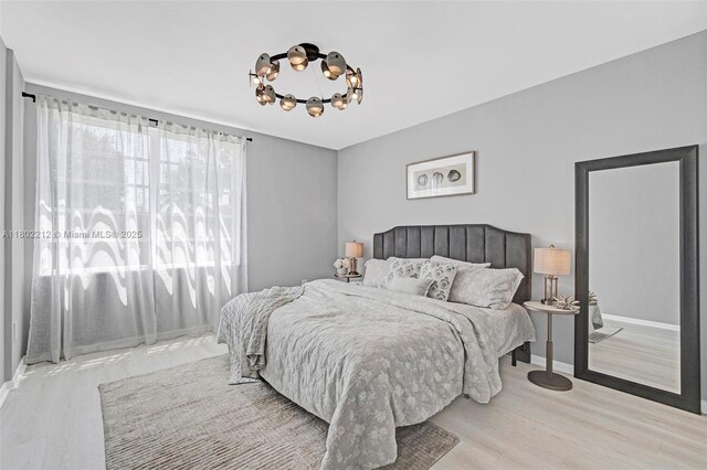 1150 Euclid Ave Unit 305, Miami Beach, FL 33139 - bedroom with a chandelier and wood finished floors