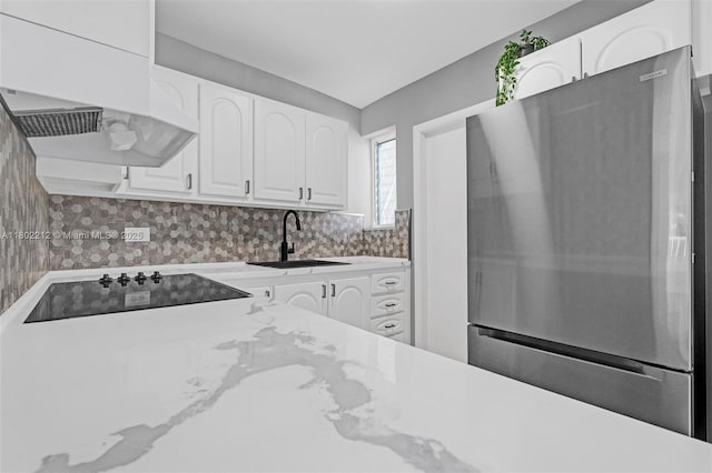 1150 Euclid Ave Unit 305, Miami Beach, FL 33139 - kitchen featuring freestanding refrigerator, black electric stovetop, white cabinets, premium range hood, and light stone countertops