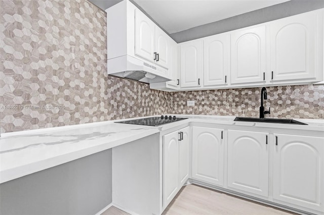 1150 Euclid Ave Unit 305, Miami Beach, FL 33139 - kitchen featuring black electric cooktop, ventilation hood, light stone counters, white cabinetry, and light wood-style flooring