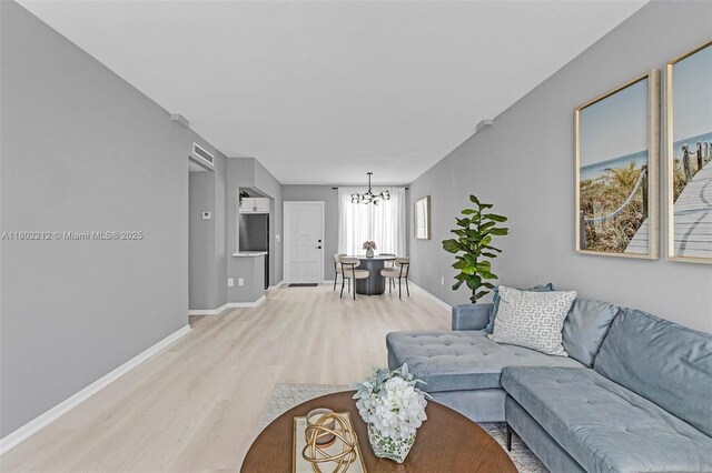 1150 Euclid Ave Unit 305, Miami Beach, FL 33139 - living room featuring wood finished floors and a chandelier